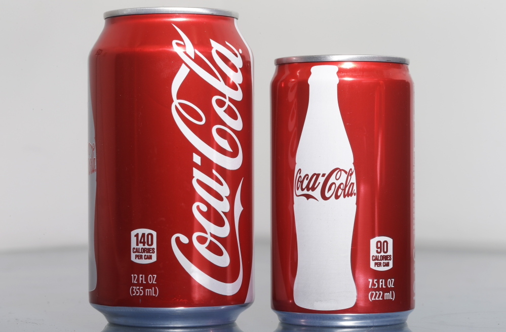 A 7.5-ounce can of Coca-Cola sits next to a 12-ounce can. As consumers cut back on soda, Coke and Pepsi are focusing on smaller cans and bottles that contain fewer calories and induce less guilt, they say.