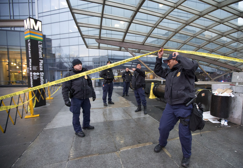 Officers secure the entrance to L’Enfant Plaza Station in Washington, Monday, following an evacuation.