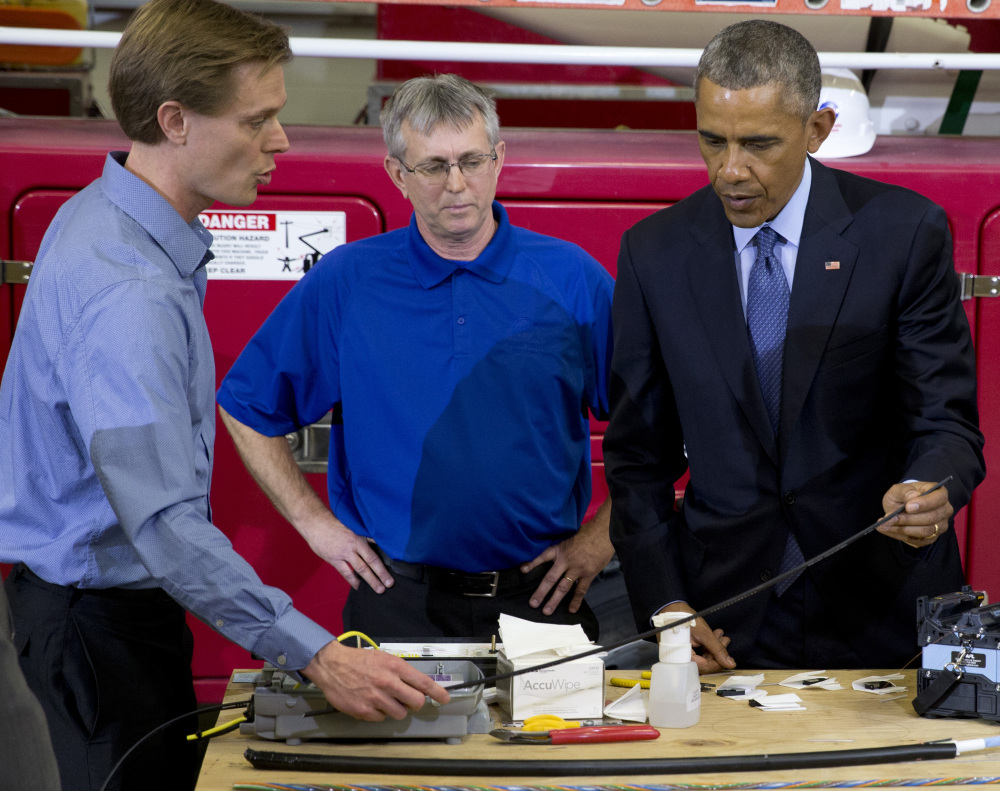 President Barack Obama joins a fiber optic splicing demonstration with Robert Houlihan, Chief Technology Officer at Cedar Falls Utilities, left, and David Schilling, Communications Services Manager.