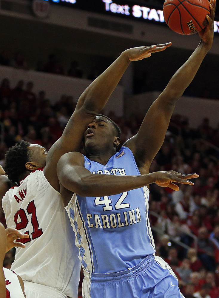 North Carolina’s Joel James tries to shoot the ball over North Carolina State’s Beejay Anya during the second half of Wednesday’s game in Raleigh, won by the Tar Heels, 81-79.