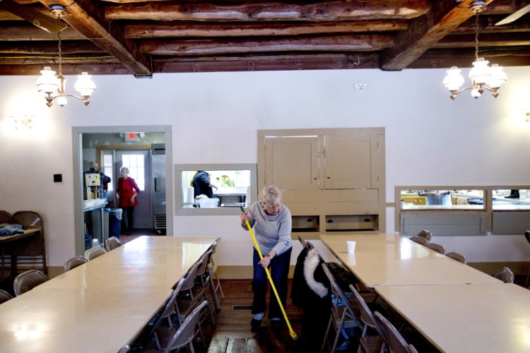 Volunteer Barbara Reaves of Freeport sweeps the hall of the Pownal Center Congregational Church after she helped serve a meal to the elderly Thursday. The 200-year-old church relies on tips and tries to serve the meals as often as possible. Under the governor’s tax plan, the town of 1,500 would probably lose revenue and could be forced to raise property taxes.