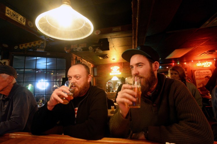 Chad Hutchins, left, and Alexander Jones of South Portland drink Foundation Epiphany IPA at the Great Lost Bear in Portland during the Industrial Park Challenge on Thursday.