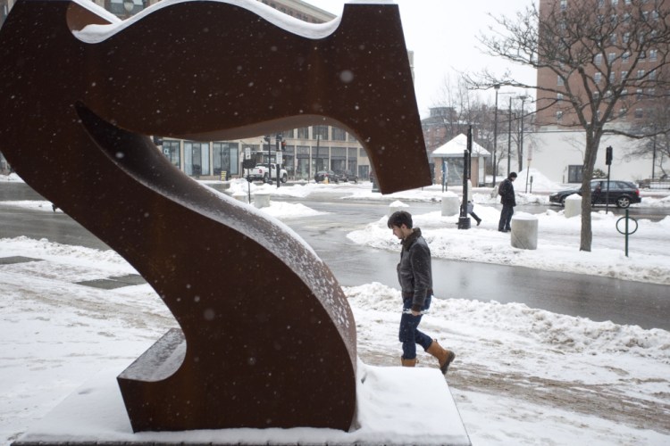 A man walks past the "Seven" sculpture in front of the Portland Museum of Art on Thursday. The sculpture was vandalized last month.
Gabe Souza/Staff Photographer