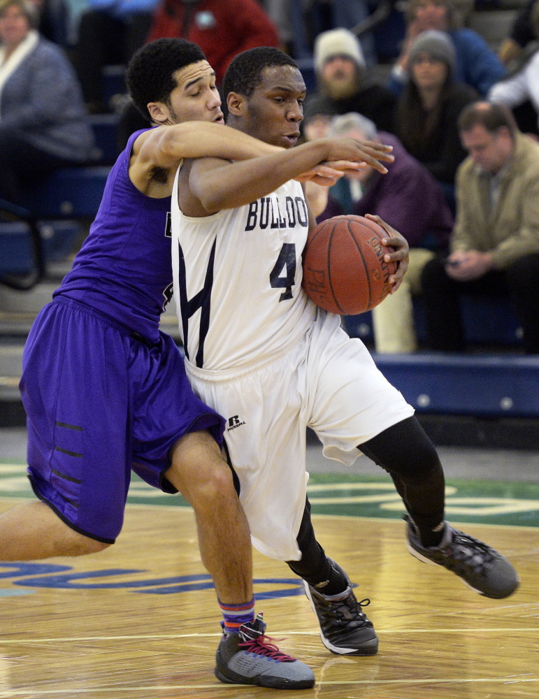 Amir Moss of Portland is fouled by Malik White of Deering while headed to the basket Thursday night during their SMAA boys’ basketball showdown at the Portland Expo. Portland won the city rivalry game, 65-62.