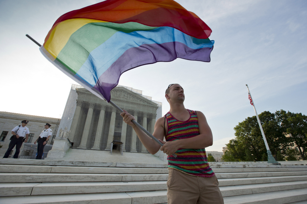 Gay rights advocate Vin Testa waves a rainbow flag in front of the Supreme Court in Washington. The justices will consider the legal debate over gay marriage in April.