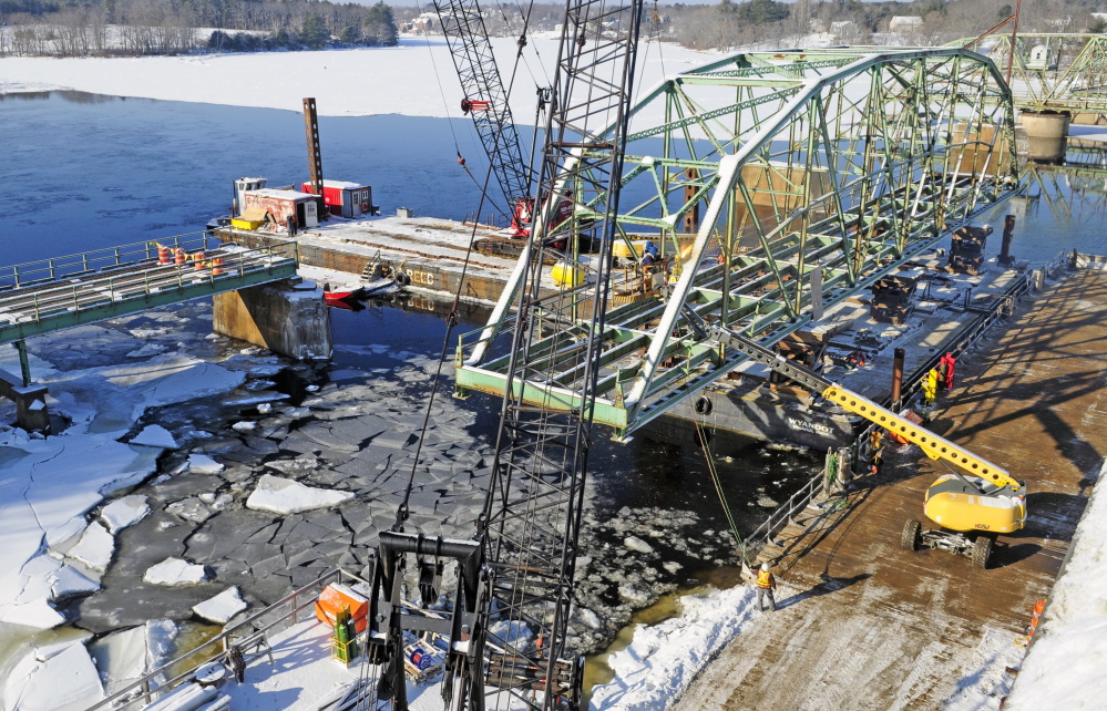 Reed and Reed Construction workers dismantle a section of the old Richmond-Dresden Bridge on Friday on a barge on the Dresden shore of the Kennebec River.