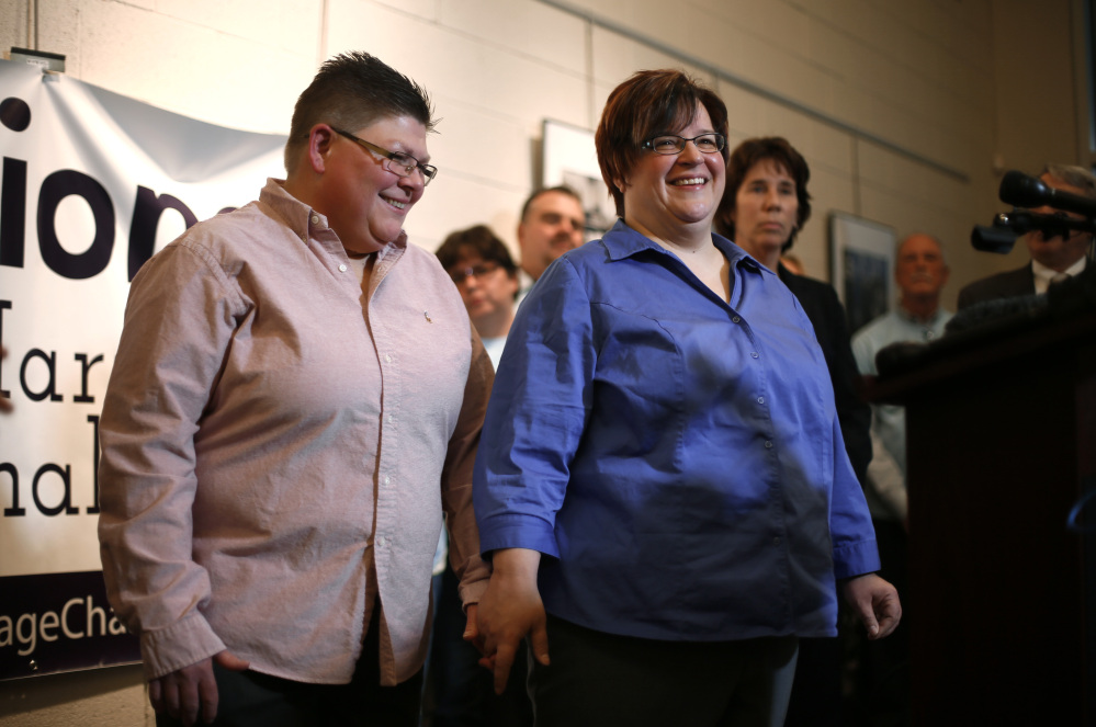 Jayne Rowse, left, and partner April DeBoer, of Hazel Park, Mich., smile during a news conference, Friday, Jan. 16, 2015, in Ferndale, Mich. Setting the stage for a potentially historic ruling, the Supreme Court says it will decide whether same-sex couples nationwide have a right to marry under the Constitution. The justices said Friday they will review an appellate ruling that upheld bans on same-sex unions in four states. Kentucky, Michigan, Ohio and Tennessee are among the 14 states where gay and lesbian couples are not allowed to marry. (AP Photo/Paul Sancya)