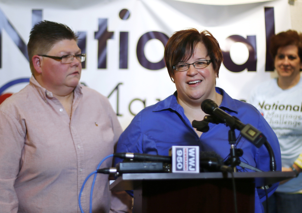 April DeBoer, right, speaks as her partner, Jayne Rowse, left, looks on during a news conference Friday in Ferndale, Mich. Setting the stage for a potentially historic ruling, the Supreme Court said Friday that it will decide whether same-sex couples nationwide have a right to marry under the Constitution.