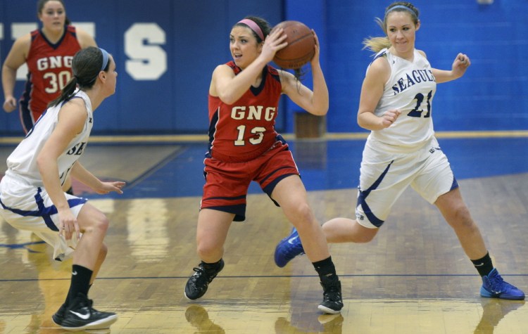 Alicia Dumont of Gray-New Gloucester looks for a teammate Friday night while guarded by Mackenzie Rague, left, and Abby Dubois of Old Orchard Beach during Gray-New Gloucester’s 52-40 victory on the road.