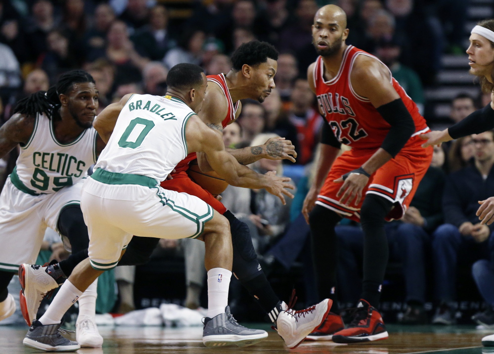 Derrick Rose of the Chicago Bulls loses control of the ball Friday night while driving past Avery Bradley, center, and Jae Crowder of the Boston Celtics in the first period of the Bulls’ 119-103 victory at Boston.