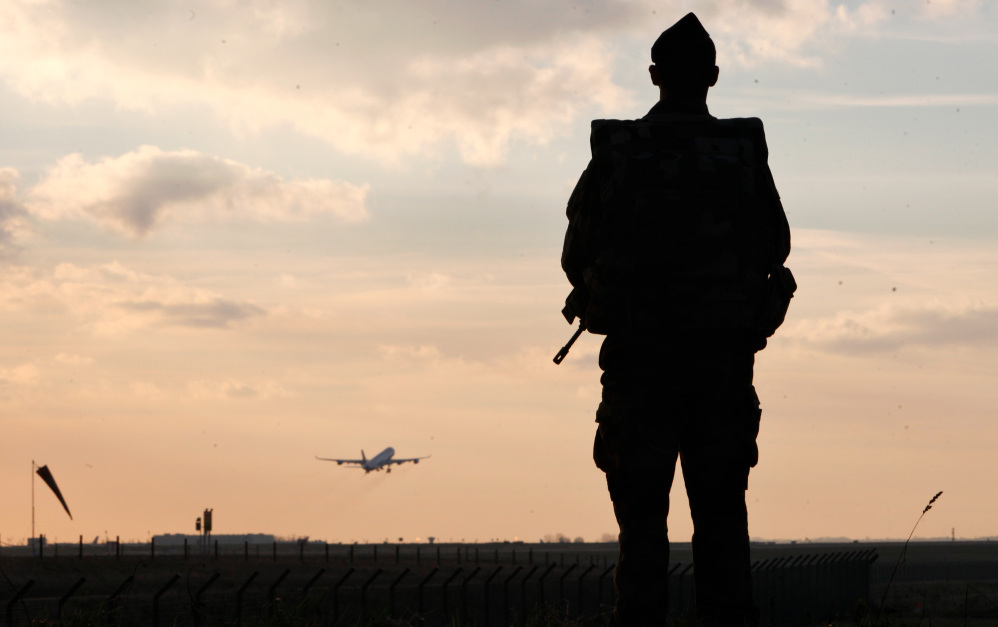 A plane takes off as a French soldier patrols at Paris Roissy Charles de Gaulle airport, in Roissy, north of Paris, on Saturday. Since last week’s attacks on a the offices of a satirical magazine, France has bolstered police presence in the streets and at sensitive sites.