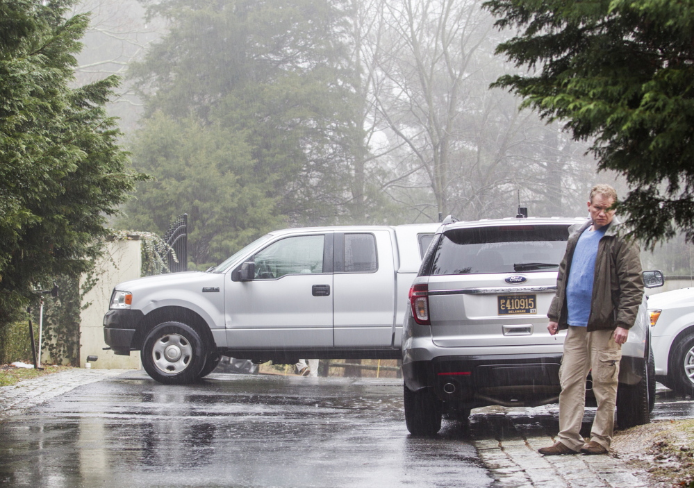 A security official stands Sunday in the driveway leading to Vice President Joe Biden’s home, a day after shots were fired from a vehicle on a public road several hundred yards away.