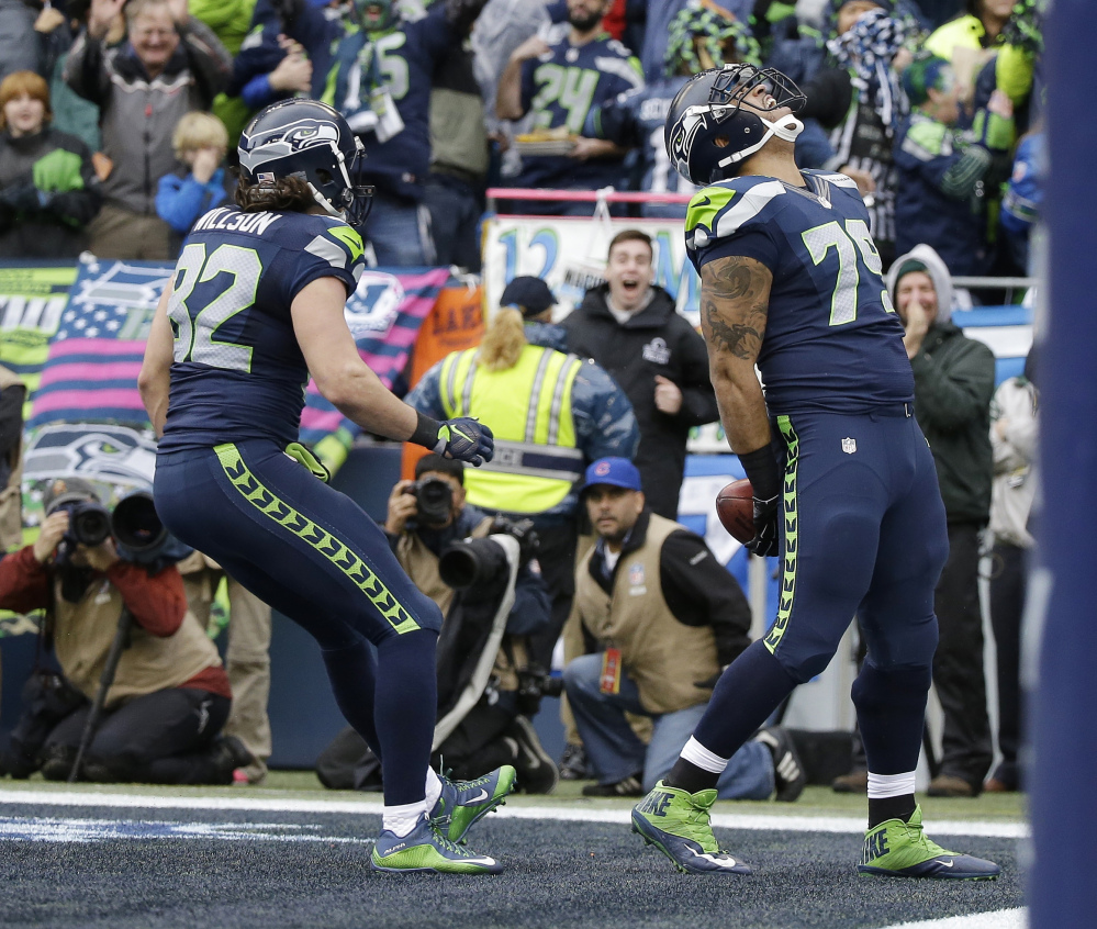 Seattle Seahawks’ Garry Gilliam reacts after catching a touchdown pass Sunday in Seattle.