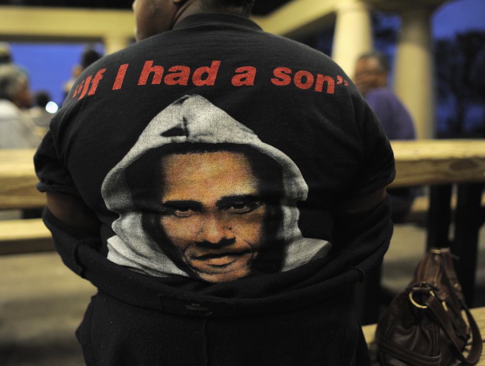 A woman wears a T-shirt with a rendering of President Obama in a hoodie before a candlelight vigil for Trayvon Martin in Sanford, Florida, in 2013. The shirt refers to Obama’s reaction to the death of the unarmed black teenager: “You know, when Trayvon Martin was first shot, I said that this could have been my son,” he said. “Another way of saying that is Trayvon Martin could have been me 35 years ago.”