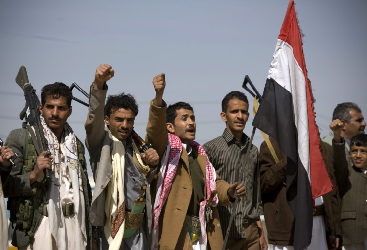 Houthi Shiite Yemenis raise their fists during clashes near the presidential palace in Sanaa, Yemen, Monday.