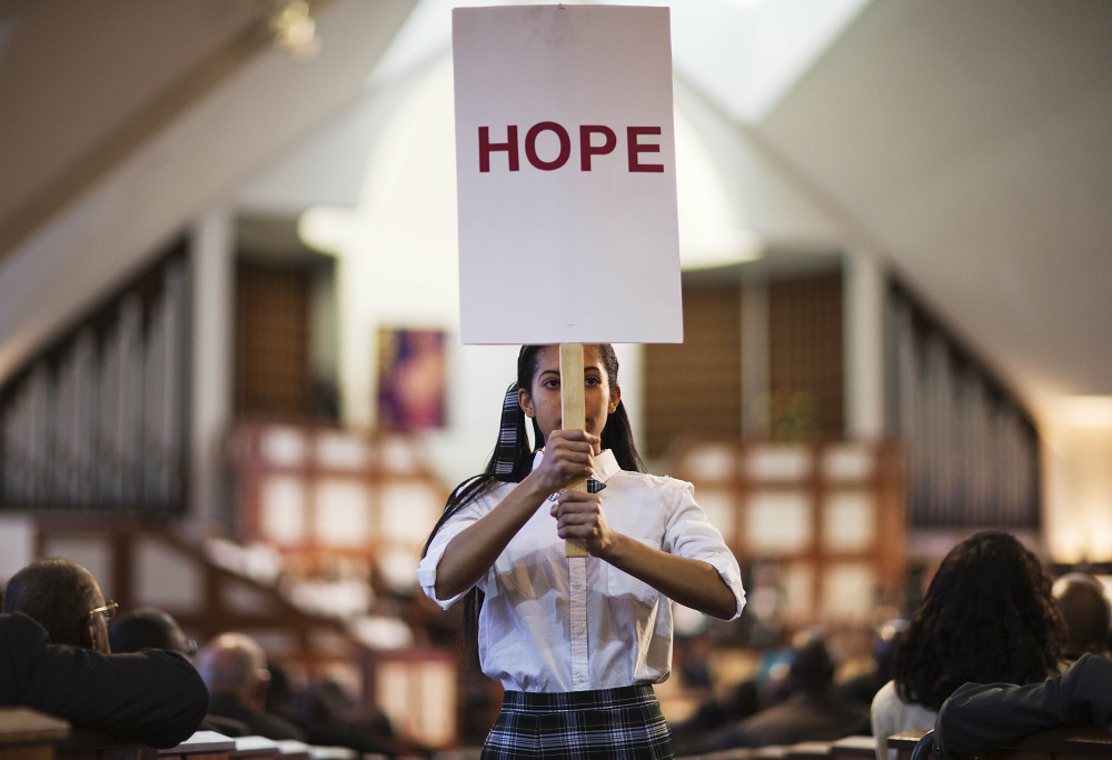 Jaiya Smith carries a sign down the aisle during a service honoring the Rev. Martin Luther King Jr. at Ebenezer Baptist Church, where King preached, on Monday in Atlanta.