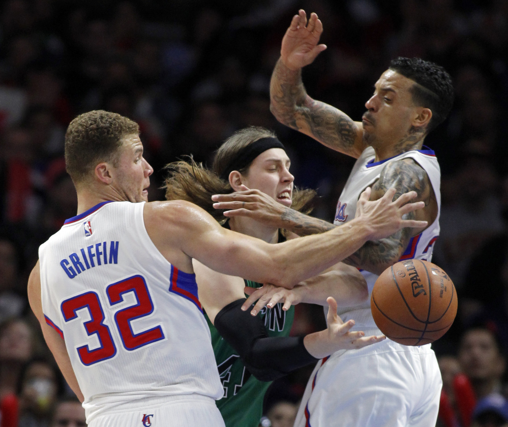 Boston Celtics center Kelly Olynyk makes a pass by Los Angeles Clippers forward Blake Griffin (32) and forward Matt Barnes during the second half of Monday’s game in Los Angeles. The Clippers won, 102-93.
