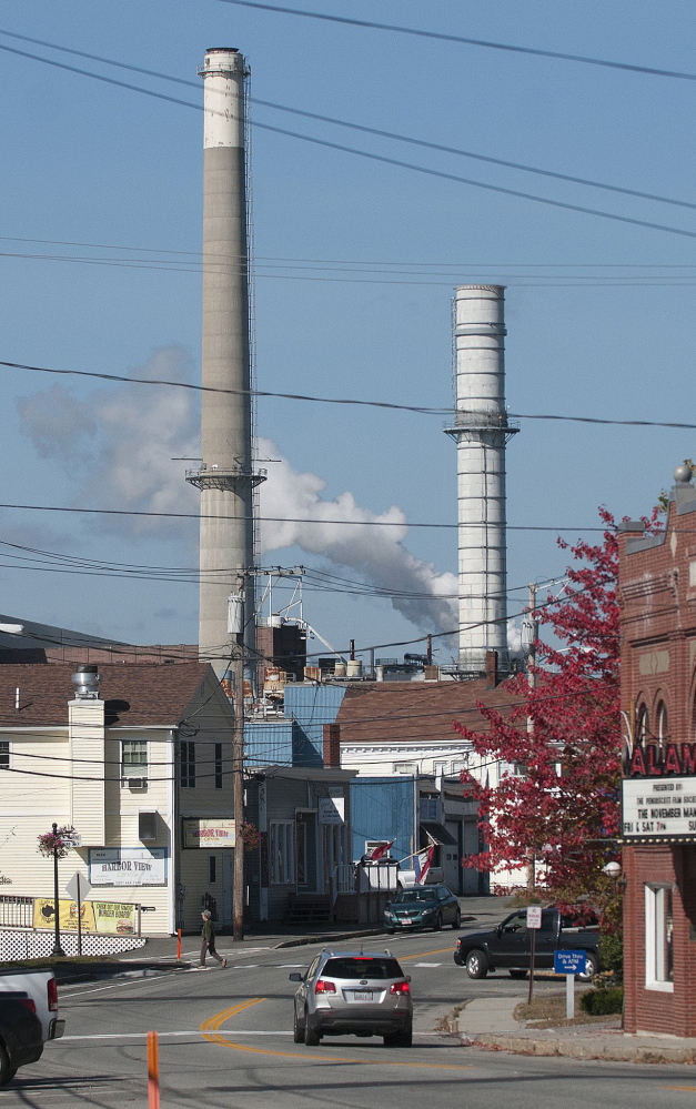 Smokestacks at Verso Paper’s mill loom over the town of Bucksport last fall. More than 500 jobs were eliminated when the mill closed in December.