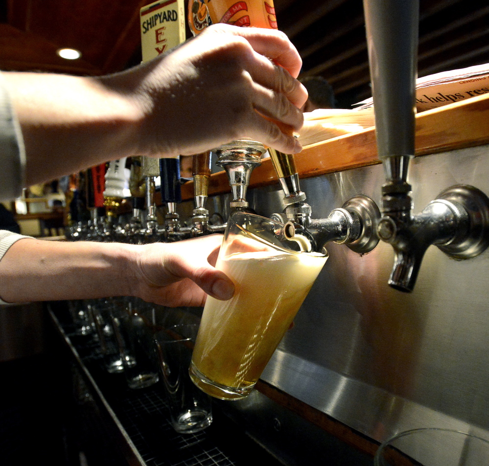 Bartender Melissa Cyr pours a pint at 3 Dollar Dewey’s in Portland. A legislator is proposing a statewide law requiring that pints are poured at a full 16 ounces.
