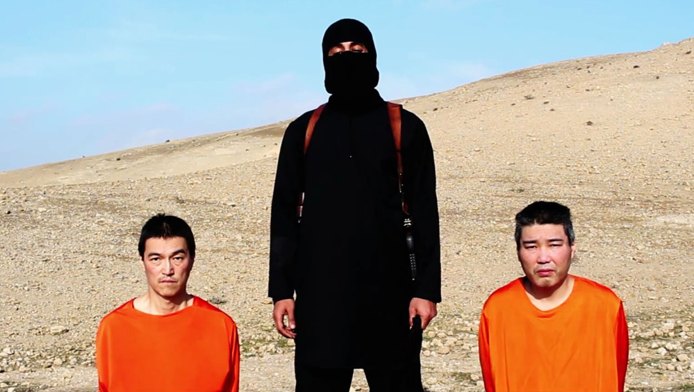 This file image taken from an online video released by the Islamic State group’s al-Furqan media arm on Tuesday, purports to show the group threatening to kill two Japanese hostages that the militants identify as Kenji Goto Jogo, left, and Haruna Yukawa, right, unless a $200 million ransom is paid within 72 hours.