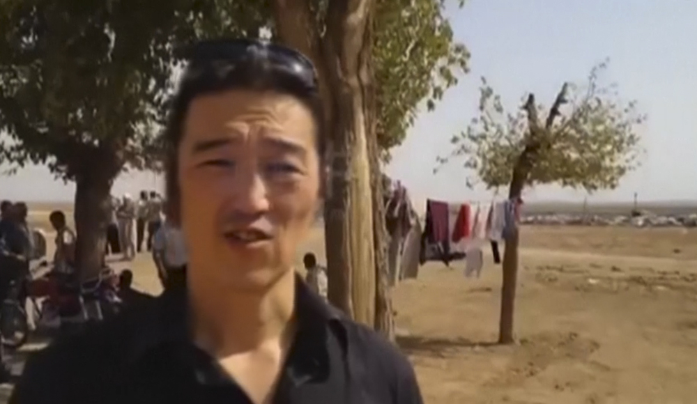 In this still image from an Oct. 3, 2014 Reportr video released by Independent Press and Pacific Bridge Media & Consulting, Japanese video journalist Kenji Goto reports from a Kurdish town on the outskirts of Kobani, Syria.