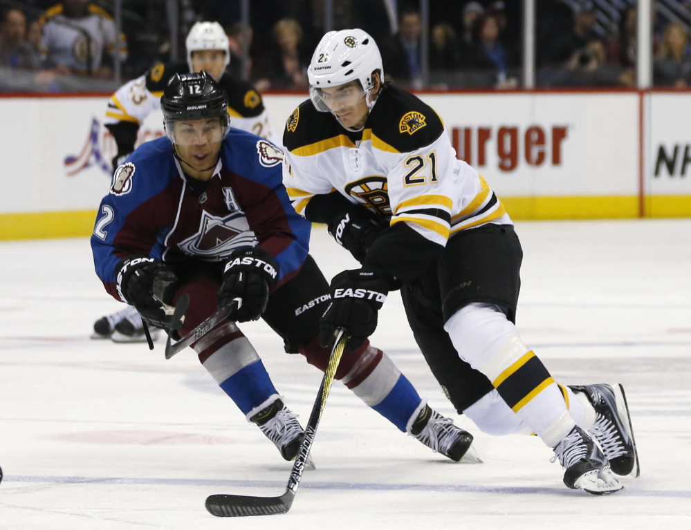 Boston Bruins right wing Loui Eriksson drives down the ice with the puck as Colorado Avalanche right wing Jarome Iginla defends in the second period of Wednesday night’s game in Denver. The Avalanche won in a shootout.