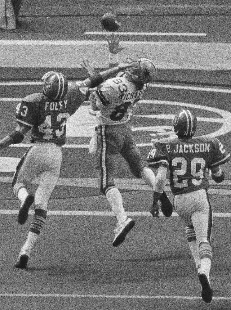 Despite the effort of Denver’s Steve Foley, left, Dallas receiver Golden Richards, center, hauls in a touchdown pass from running back Robert Newhouse in 1978.