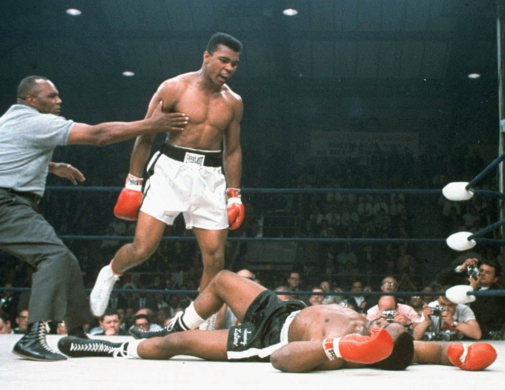 Muhammad Ali is held back by referee Jersey Joe Walcott after Ali dropped challenger Sonny Liston less than two minutes into the first round of their heavyweight title fight in Lewiston on May 25, 1965.