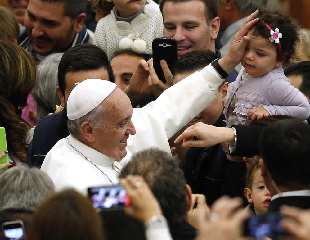 Pope Francis blesses a child as he arrives to lead a special audience for Vatican employees and their families at the Vatican last month.