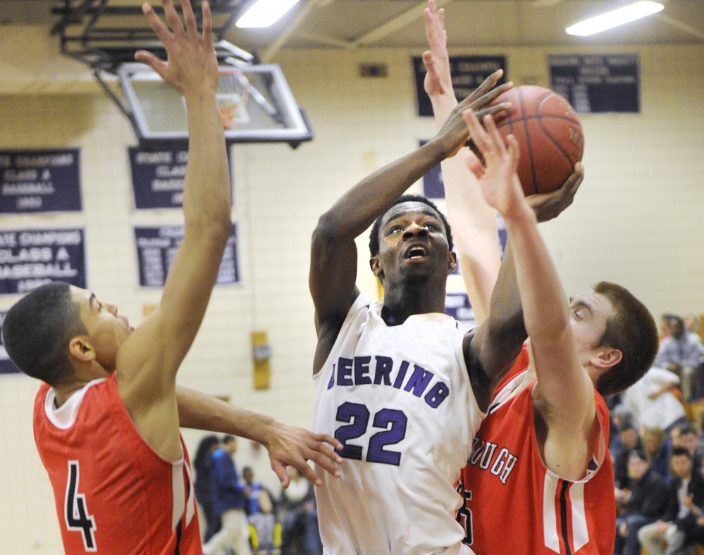 Benedict Williams of Deering looks for room to shoot between Milani Hicks, left, and Jacob Gardner of Scarborough during Deering’s 77-73 victory in an SMAA game Friday night. Williams finished with 27 points.