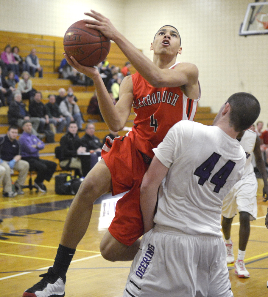 Milani Hicks, who scored 20 points for Scarborough, heads to the basket while guarded by Raffaele Salamone of Deering. The Rams improved their record to 10-4 and dropped Scarborough to 7-8.
