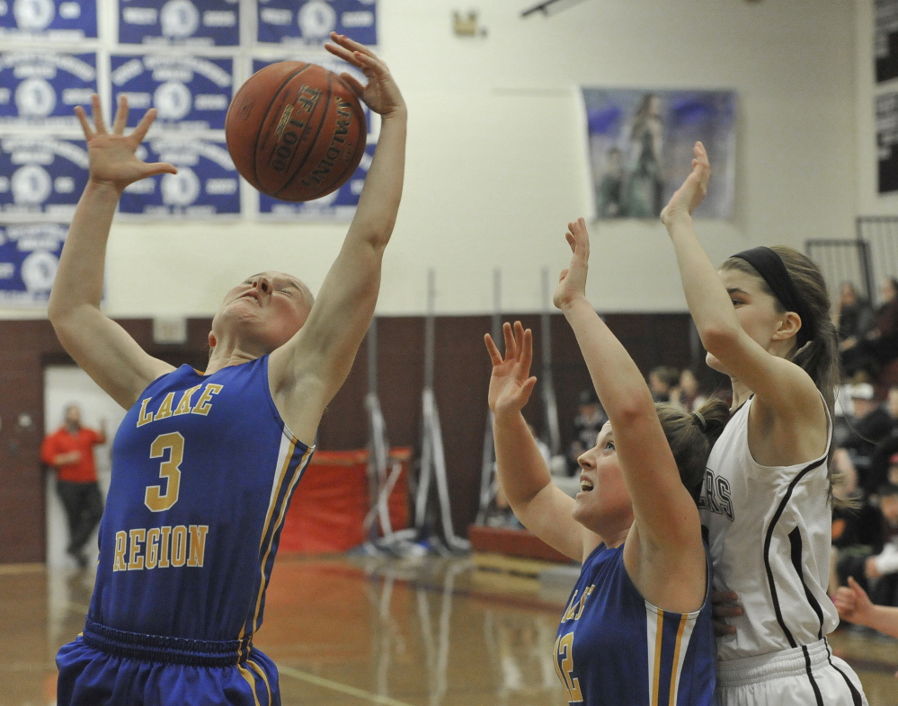 CeCe Hancock of Lake Region takes control of a rebound Friday night, pulling down the ball in front of her teammate, Sarah Hancock, during a 52-30 loss to Greely at Cumberland.
