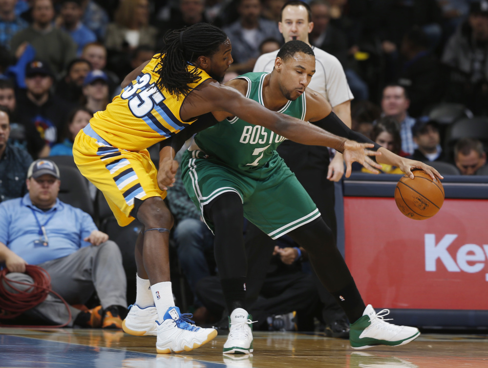 Denver Nuggets forward Kenneth Faried tries to steal the ball from Boston Celtics center Jared Sullinger, who works the ball inside for a shot in the first quarter of Friday night’s game in Denver. The Celtics won their second straight game. The Associated Press