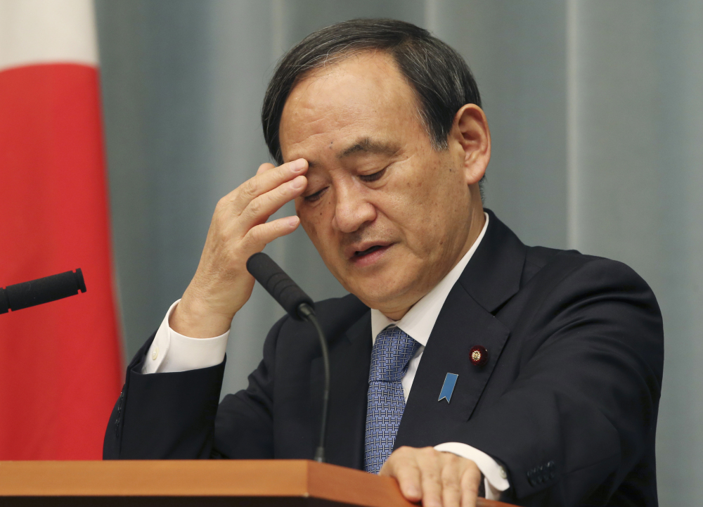 Japan’s government spokesman Chief Cabinet Secretary Yoshihide Suga ponders a question during a news conference in Tokyo on Friday after militants affiliated with the Islamic State group posted an online warning that the “countdown has begun” for the group to kill the pair of Japanese hostages.