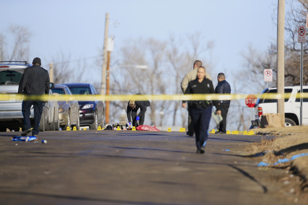 Crime lab investigator and police officers work the scene of a shooting in Omaha, Neb.