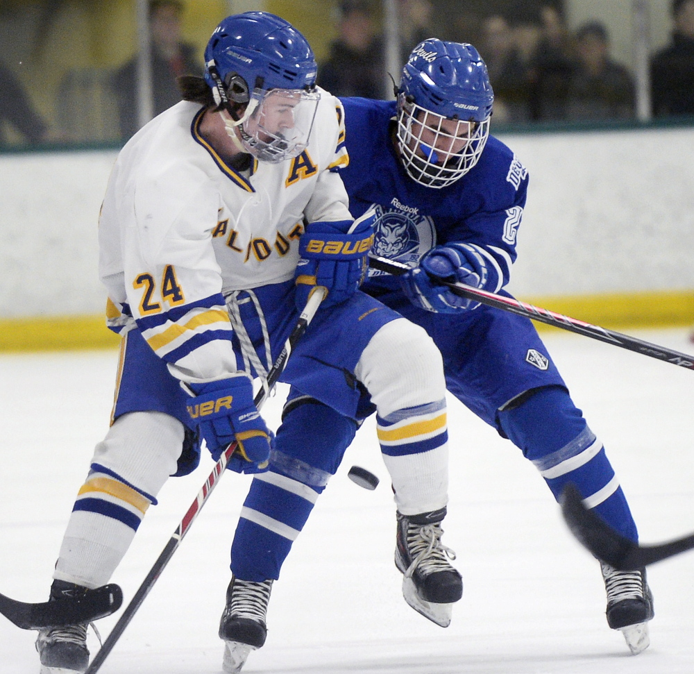 Falmouth’s Jake Grade, left, battles for the puck with Lewiston’s Brendon Croteau during a 5-2 win by the Blue Devils at Falmouth on Monday. Lewiston improves to 8-3-1 with the win; Falmouth is 9-4.