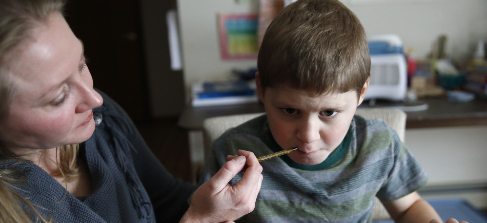 Nicole Gross gives son Chase a medical cannabis oil. The family moved from Chicago to Colorado to legally treat Chase, who used to have multiple seizures daily.