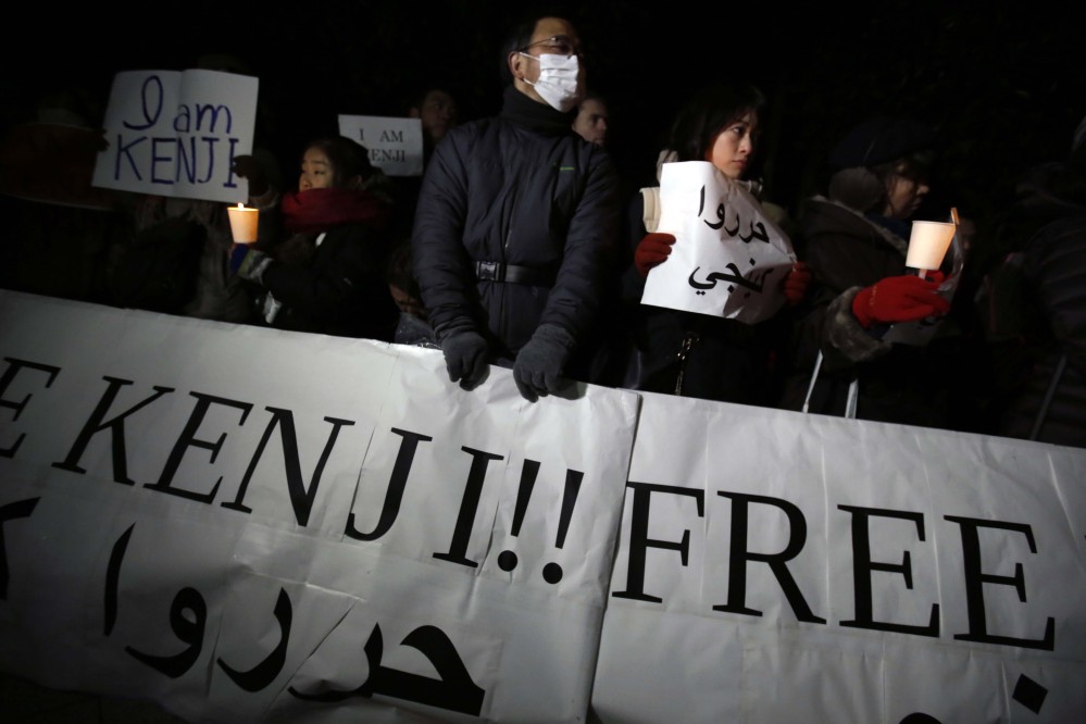 Protesters hold signs stating “I am Kenji” and “Free Kenji” in English and Arabic during a rally outside the prime minister’s official residence in Tokyo, Wednesday.