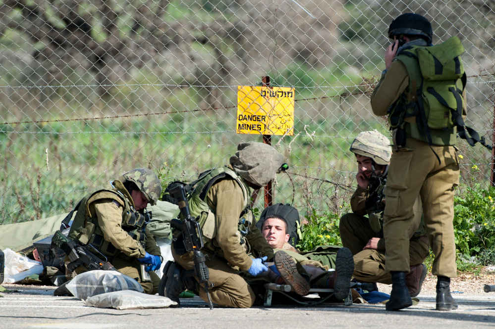 Israeli soldiers treat a wounded soldier near the Israel-Lebanon border, on Wednesday.