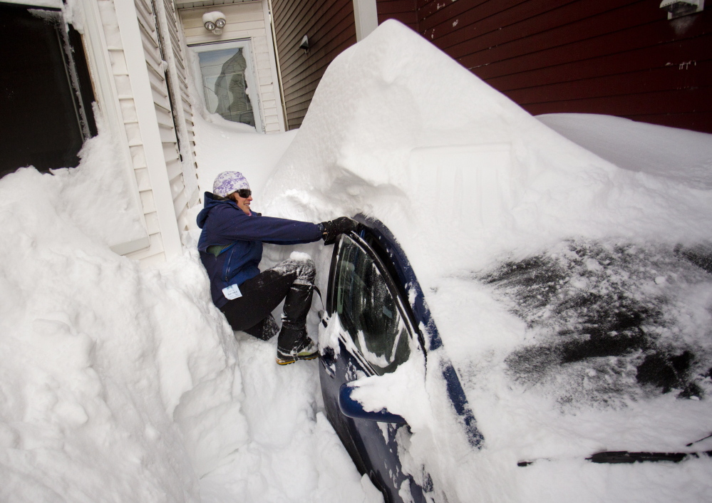 Bonnie Frye Hemphill yanks on her car door as she tries to wedge herself in while digging out of her driveway on North Street Wednesday after a blizzard dumped more than two feet of snow on Portland. Forecasters attach little meaning to predictions of more snow in the near future.