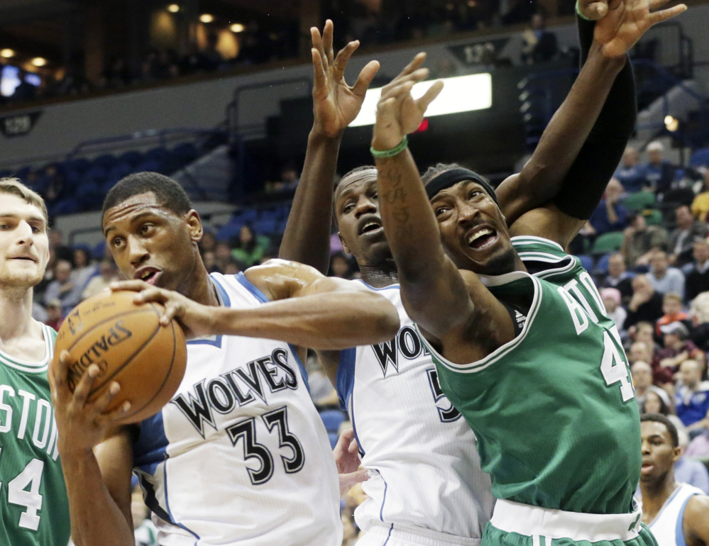 The Minnesota Timberwolves’ Thaddeus Young, left, beats the Celtics’ Gerald Wallace, right, to the rebound in the first quarter of Wednesday night’s game in Minneapolis. Young had 12 points and nine rebounds in the game.