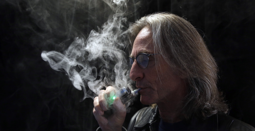 John Hartigan, proprietor of Vapeology LA, takes a puff of an electronic cigarette at his store in Los Angeles.
The Associated Press