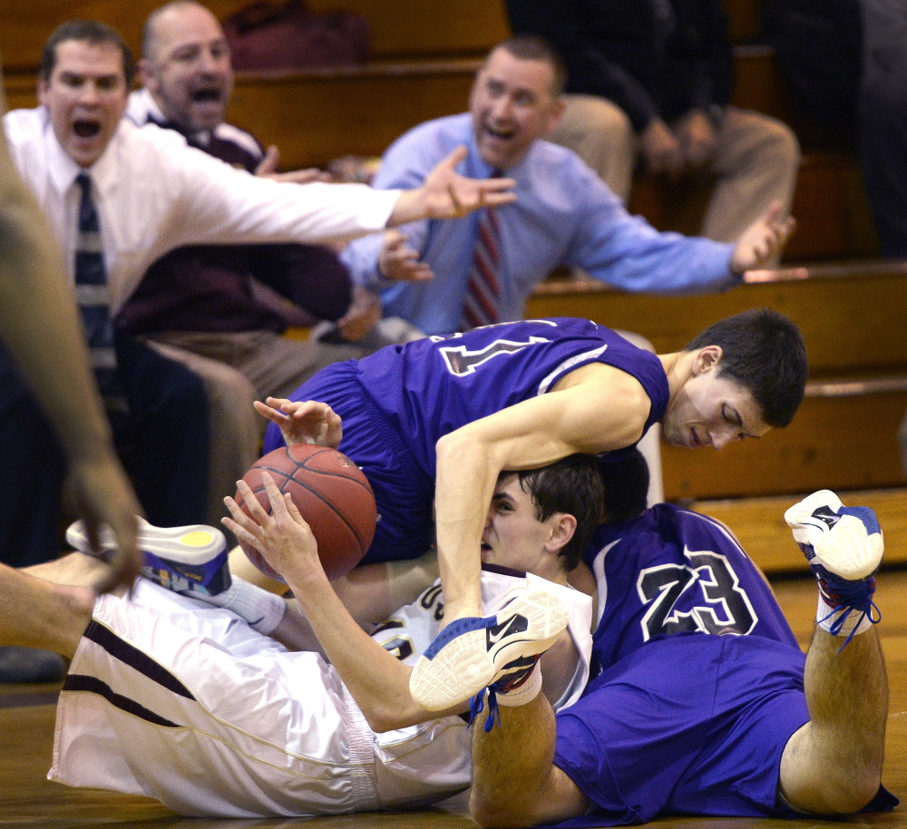 With his coaching staff pleading for a call, Benjamin Lambert of Thornton Academy, center, competes for a loose ball with Kyle Parmley, left, and Noah McDaniel of Marshwood during Marshwood’s 46-45 victory Wednesday night at Saco.
