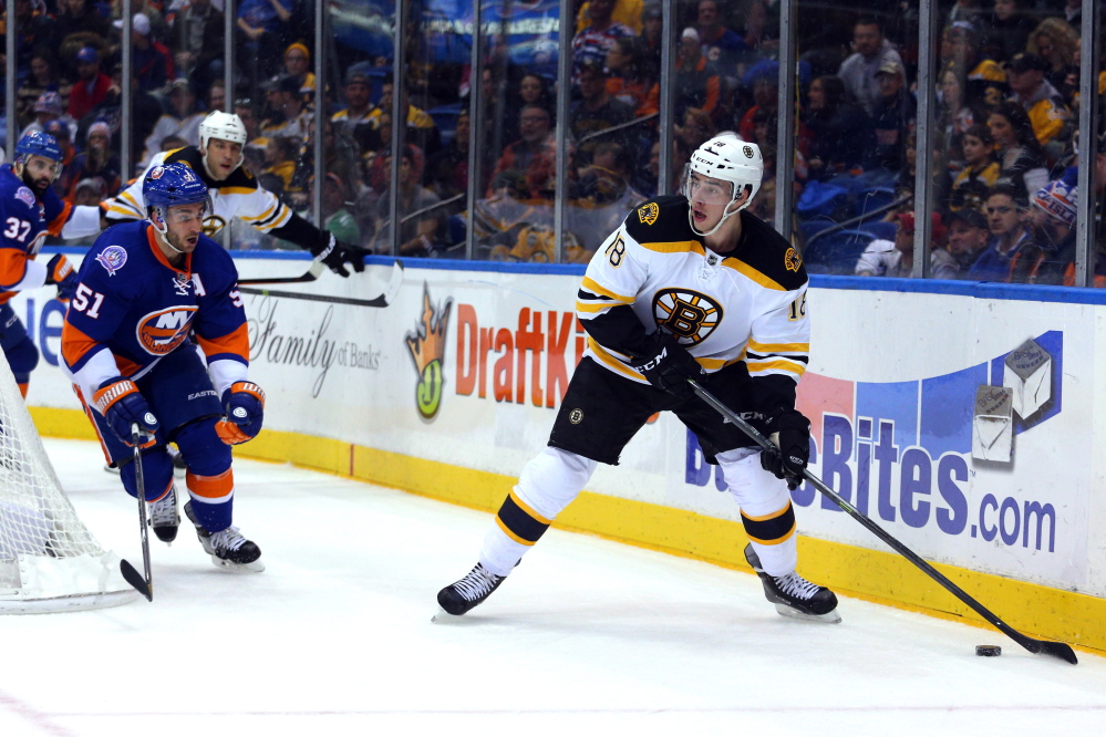 Bruins right wing Reilly Smith controls the puck as Islanders center Frans Nielsen closes in during the first period Thursday night. Smith had a goal and two assists to help boost Boston to a 5-2 win in Uniondale, N.Y.