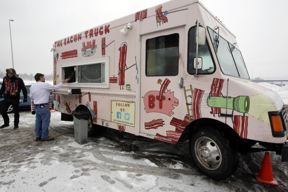 Visitors get free bacon samples from The Bacon Truck on Friday outside the welcome center in Hooksett, N.H.
