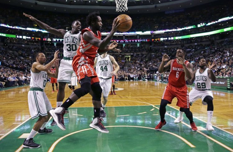 Houston Rockets guard Patrick Beverley looks to pass as he is pressured by Boston Celtics forward Brandon Bass (30) during the second quarter of Friday night’s game in Boston. The Rockets won their fourth straight game.