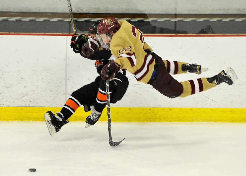 Biddeford’s Joe Anders, left, and Thornton Academy’s Chase Wescott are knocked off their skates after a collision. Anders was one of four goal scorers for Biddeford, which has lost only once in its last seven games.