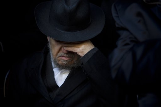 A relative of French Jew Yoav Hattab, a victim of the attack on kosher grocery store in Paris, attends his funeral procession in the city of Bnei Brak near Tel Aviv Tuesday. The Associated Press