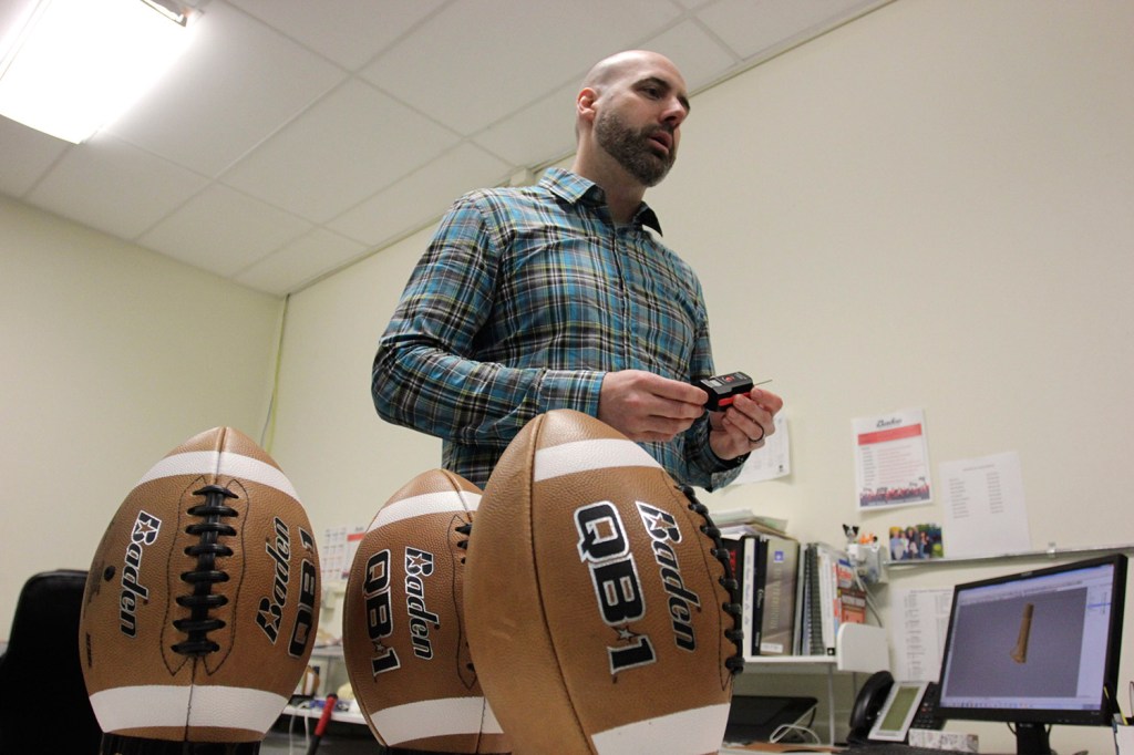Baden Sports researcher director Hugh Tompkins shows footballs with different air pressures to be used in a demonstration, in Renton, Wash., on Thursday. Former Patriots quarterback Hugh Millen, who now helps design footballs for Baden, says quarterbacks prefer footballs with less air because of better grip and faster throws. 