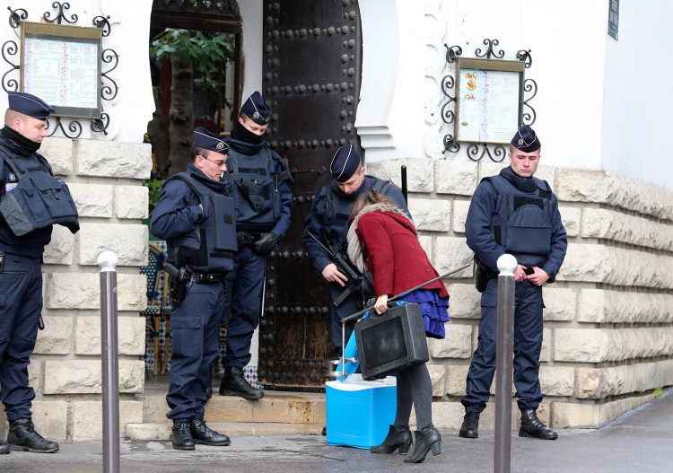 Riot police officers check a woman at the Grand Mosque of Paris, France, on Wednesday, one week after the attack on a satirical newspaper. 